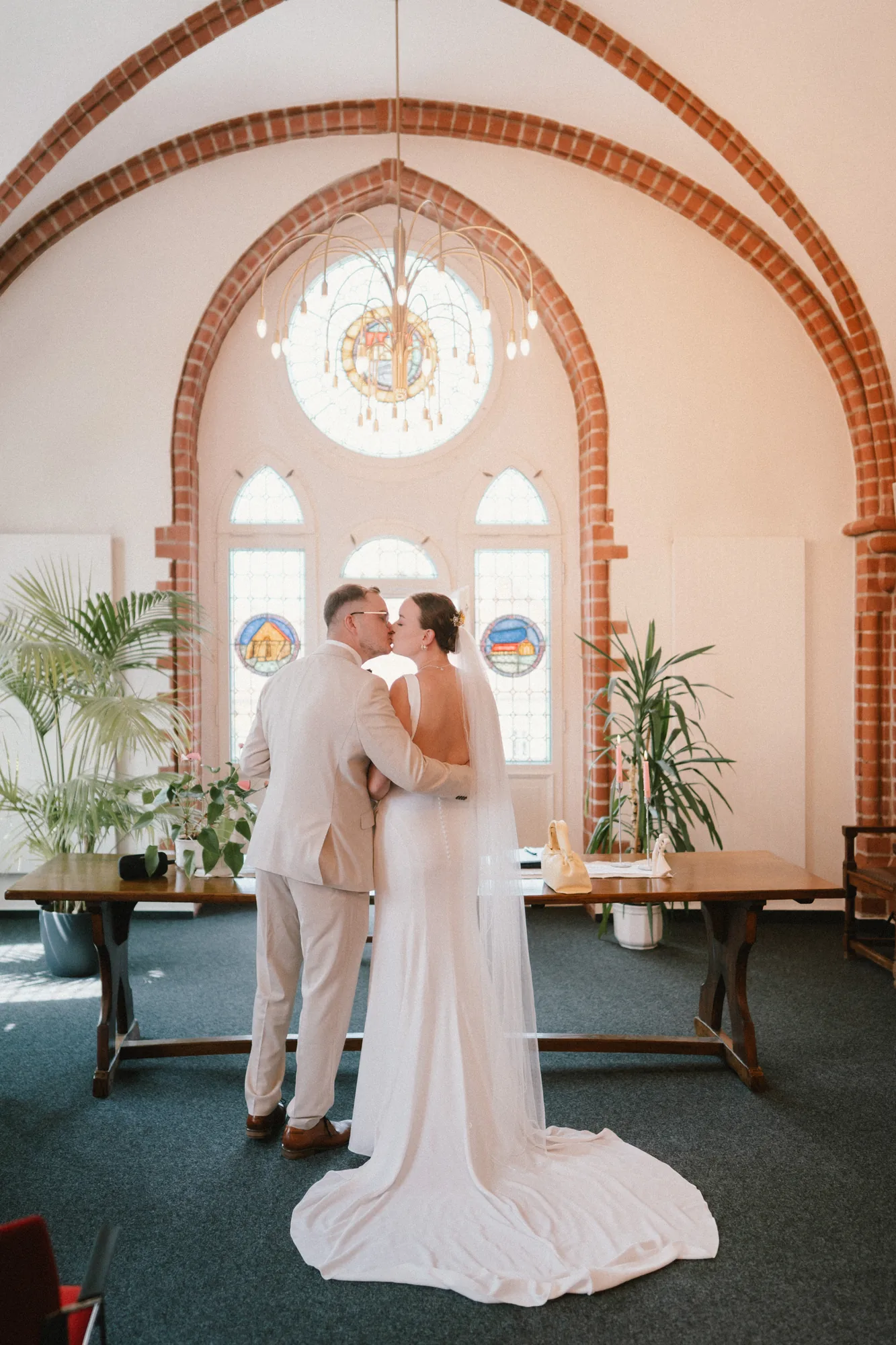 Hochzeitsfotograf Standesamt Unterspreewald — Rathaus Golßen 2 Hochzeitsfotograf Standesamt Unterspreewald Rathaus Golßen – Brautpaar beim Kuss vor dem Bleiglasfenster im Treppenhaus d